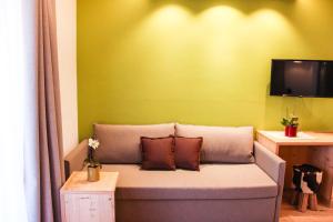 a couch in a room with a green wall at Naturhotel Miraval in Perca