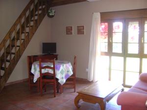 a living room with a table and a staircase at Apartamentos Dos Robles in Somo