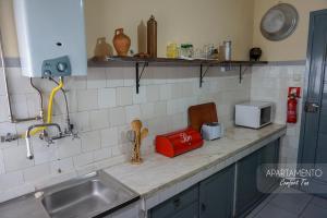 a kitchen counter with a sink and a microwave at Comfort Tua in Mirandela +60 photos