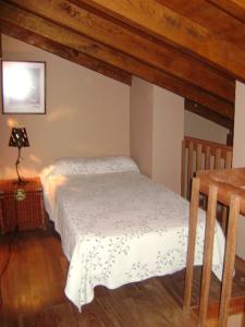 a small bedroom with a bed and a table at Apartamentos Dos Robles in Somo