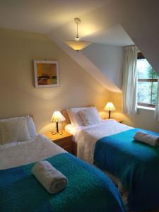 a bedroom with two beds and two lamps and a window at Tranquil sea view in Kenmare in Kenmare