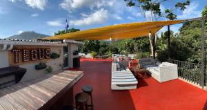 a patio with a large yellow umbrella on a deck at Palmira Hostel in Tegucigalpa