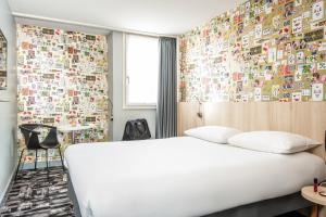 una habitación de hotel con una cama y una pared cubierta de pegatinas en ibis Styles Reims Centre, en Reims