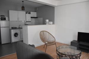 sala de estar con mesa y silla y cocina en Le Midi 3 en Trèbes