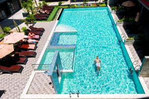 un hombre está parado en una piscina en Coco Bella Hotel en Phi Phi Don