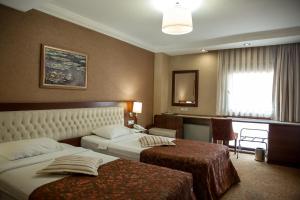 イスタンブールにあるYuksel Hotelのベッド2台と窓が備わるホテルルームです。