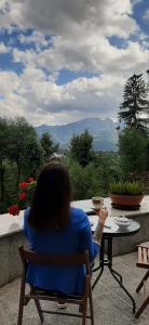 a woman sitting in a chair looking out at a table at Nauczycielskie Centrum in Zakopane