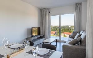 uma sala de estar com um sofá e uma mesa com copos de vinho em Apartamentos Onzamar em Sanxenxo