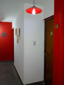 a hallway with red and white walls and a door at Destino San Juan Hostel in San Juan