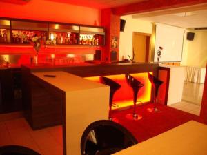 a bar with a counter and chairs in a room at Hotel Ristorante La Rua in Carre