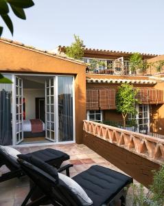 un patio con 2 sillas y una cama en un edificio en Llimona Suites - Adults Only, en Corçà