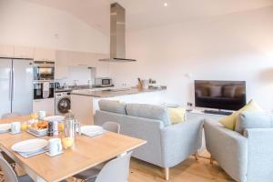 a kitchen and living room with a table and chairs at 8 Deben Wharf in Woodbridge