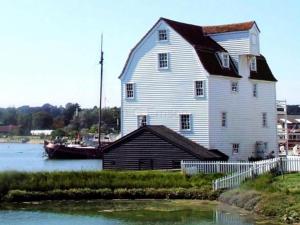 a large white house with a boat in the water at 8 Deben Wharf in Woodbridge