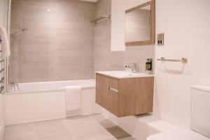 a bathroom with a tub and a sink and a shower at 8 Deben Wharf in Woodbridge