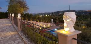 a white statue sitting on top of a fence at Hotel Villa Flora Relais in Caltanissetta