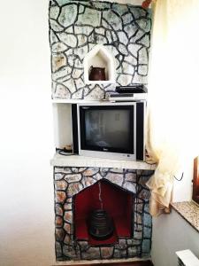 a tv sitting on top of a stone fireplace at Apartment Nono Anton in Kraljevica
