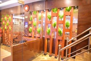 um lobby com vasos de plantas na parede em Hotel White Boutique em Pondicherry