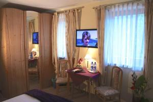 Pokój z sypialnią ze stołem i telewizorem na ścianie w obiekcie Land-gut-Hotel Gasthof Waldschänke w mieście Altfraunhofen