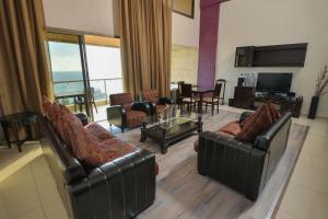 a living room with leather couches and a television at Hollywood Inn Boutique Hotel in Jounieh