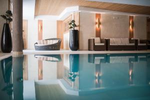 索爾達的住宿－Hotel Lärchenhof，一间带游泳池和沙发的客厅