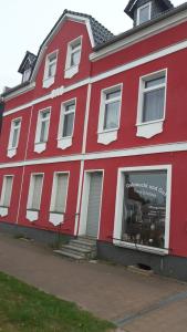 a red building with a store in it at Ferienwohnung zum Schuster in Halbe