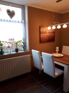 a dining room with a table and chairs and a window at Ferienwohnung zum Schuster in Halbe +4 photos