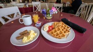 a pink table topped with waffles and breakfast foods at Hotel Grand Victorian in Branson