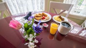 uma mesa com comida de pequeno almoço e café e flores sobre ela em Hotel Grand Victorian em Branson