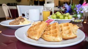 um prato branco com waffles e waffleergy em Hotel Grand Victorian em Branson