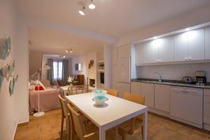 a kitchen and living room with a table and chairs at Ca na Magdalena - La Goleta Villas in Port de Pollensa