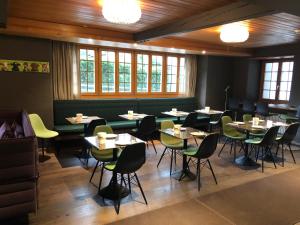 - une salle à manger avec des tables, des chaises et des fenêtres dans l'établissement Hotel Sternen, à Lenk im Simmental