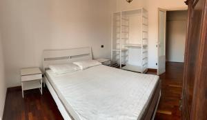 a bedroom with a white bed and a wooden floor at Colosseo Boutique Apartment in Rome