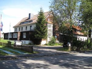 una casa grande con una valla delante en Hotel & Hostel Drei Bären en Altenau