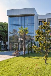 a large glass building with a park in front of it at iHotel Sunny Beach in Sunny Beach