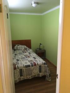 a bedroom with a bed with a quilt on it at Hogar Doña Gloria in Iquique