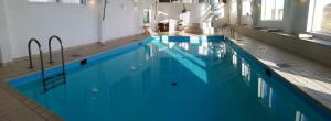 - une grande piscine d'eau bleue dans un bâtiment dans l'établissement Løgstør Parkhotel, à Løgstør