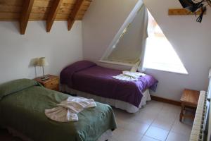 1 dormitorio con 2 camas y ventana en Hotel Arquimedes en Caviahue