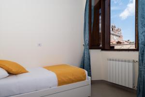Schlafzimmer mit einem Bett und einem Fenster in der Unterkunft Minerva Monks Inn in Rom