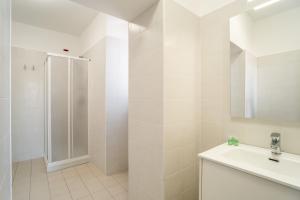 ein weißes Bad mit einer Dusche und einem Waschbecken in der Unterkunft Minerva Monks Inn in Rom