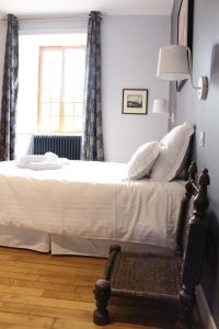 a bedroom with a bed and a lamp and a window at Hôtel Les Empreintes in Saint-Évarzec