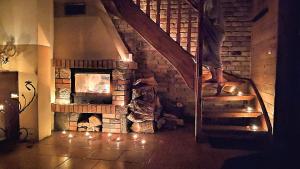 a staircase in a room with a brick fireplace at Oryginalna Mazurska Chata nad jeziorem w środku lasu - Szeroki Bór in Szeroki Bór