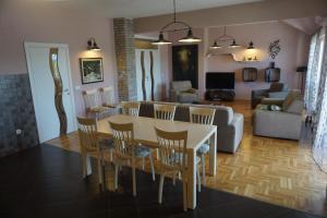 a dining room and living room with a table and chairs at Toholj in Trebinje