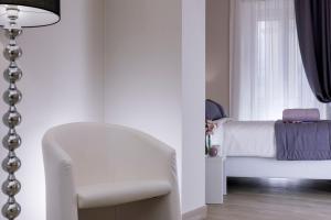 1 dormitorio con una silla blanca y una ventana en St. Peter Fortytwo, en Roma