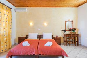 1 dormitorio con 2 camas con sábanas rojas y espejo en Konstantinos Beach 2 en Limenaria