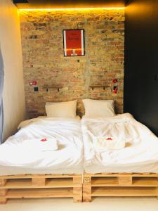 2 camas en una habitación con una pared de ladrillo en Retro Apartments, en Rzeszów