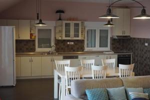 a kitchen with white cabinets and a table and chairs at Toholj in Trebinje