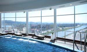 a large swimming pool in a building with windows at MDS Hotel Concepción in Concepción