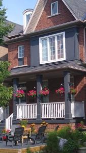 een huis met stoelen en bloemen op de veranda bij Village at York U in Toronto