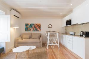 Il dispose d'une cuisine et d'un salon avec un canapé et une table. dans l'établissement FLH Anjos Lovely Apartment, à Lisbonne