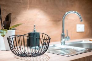 a kitchen sink with a metal basket on the counter at Hypercentre Charmant 2 Chambres Au Calme avec Joli Patio Privatif in Nantes +21 photos